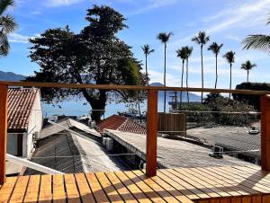 una terraza con vistas al océano y a las palmeras en Suite Charme apt 10, en Ilhabela