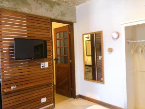 Una habitación con un televisor de pantalla plana en una pared. en Suite Charme apt 10, en Ilhabela
