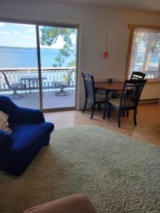The Point - On Gull Lake في برينرد: غرفة معيشة مع طاولة وكراسي وإطلالة على المحيط