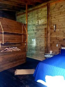 a bedroom with a bed and wooden walls at Chalés Paris in Paraty
