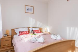 Una cama con almohadas rojas y toallas blancas. en Holiday House "Słoneczna" with Garden by Renters en Łukęcin