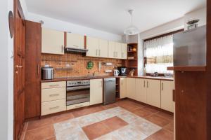 a kitchen with white cabinets and stainless steel appliances at Holiday House "Słoneczna" with Garden by Renters in Łukęcin