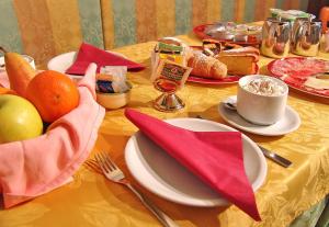 een tafel met borden eten en fruit erop bij Jolly B&B - Affittacamere in Dimaro