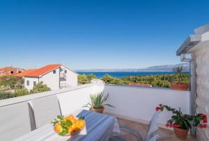 a table with a bowl of fruit on a balcony at Family friendly apartments with a swimming pool Supetar, Brac - 16774 in Supetar