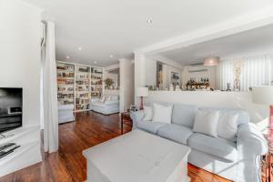 un soggiorno bianco con divano e tavolo di Casa da Praia a Estoril