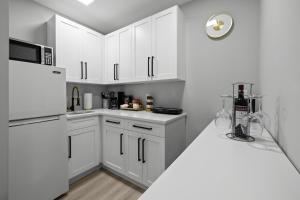 uma cozinha branca com armários brancos e um frigorífico em Tropical Paradise em Cape Coral