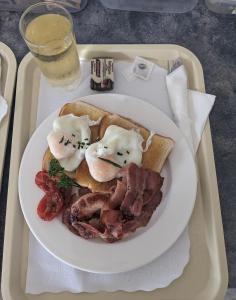 un piatto di cibo con uova e pancetta su un vassoio di Kaputar Motel a Narrabri