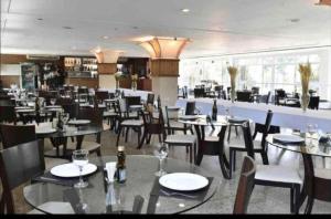 uma sala de jantar com mesas e cadeiras num restaurante em Gran Lençóis Flat Residence Apartamento Atins 109 em Barreirinhas