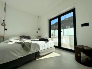 ein Schlafzimmer mit einem Bett und einem großen Fenster in der Unterkunft Santa Rita Sunset & Beach Apartment in Maceira