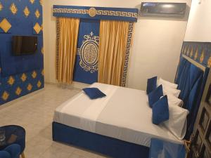 a bedroom with a bed with blue and yellow curtains at Defence Guest House in Karachi