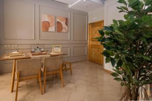 Luxury Apartment Airport في نواصير: غرفة بطاولة وكراسي ومصنع