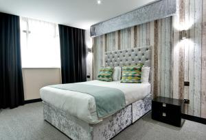 ein Schlafzimmer mit einem großen Bett mit großem Kopfteil in der Unterkunft Print Works Hotel in Liverpool