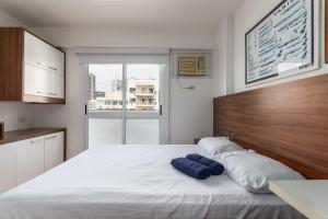 a bedroom with a large white bed with two blue towels at Apt completo com piscina e área de lazer em BOTAFOGO in Rio de Janeiro +30 photos