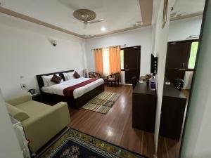 um quarto com uma cama, um sofá e uma cadeira em Hotel Chhutuk Heights em Kargil
