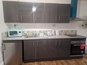 a kitchen with a sink and a microwave at Lovely 1 bedroom apartment in Bristol