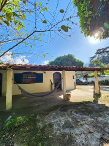 un edificio con una hamaca delante en Hospedaria e Camping Quintal do Mundo en Lumiar