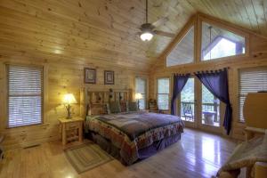 ein Schlafzimmer mit einem Bett in einer Holzhütte in der Unterkunft Go Fish- Fightingtown Creek Frontage in McCaysville