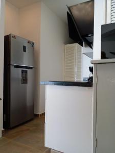 a kitchen with a refrigerator and a microwave at Ocean Pacific appartment in Acapulco