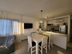 cocina y comedor con mesa y sillas en Torres Al Mar - Dto 4to C en Monte Hermoso
