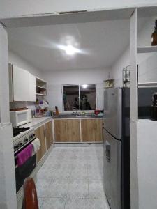 een keuken met houten kasten en een roestvrijstalen koelkast bij Casa Bondigua in Santa Marta