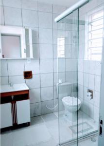 een badkamer met een toilet en een glazen douche bij Casa apto Bento Gonçalves Serra Gaúcha in Bento Gonçalves