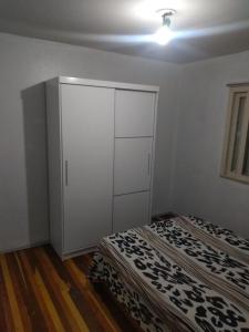 een slaapkamer met een witte kast en een bed bij Casa apto Bento Gonçalves Serra Gaúcha in Bento Gonçalves