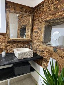 La salle de bains en pierre est pourvue d'un lavabo et d'un miroir. dans l'établissement Monte da Parreira, à Cabeça de Carneiro