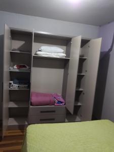 een slaapkamer met een kast met planken en een bed bij Casa apto Bento Gonçalves Serra Gaúcha in Bento Gonçalves