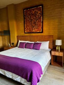a bedroom with a large bed with purple sheets at Casa Patio in San Sebastián del Oeste