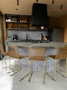 a kitchen with a counter with chairs around it at Casa Patio in San Sebastián del Oeste
