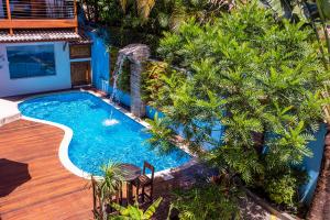 an overhead view of a swimming pool with palm trees at Pousada Vila Barequeçaba in São Sebastião