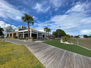 a house with a palm tree and a wooden walkway at Third Floor Score in Calabash