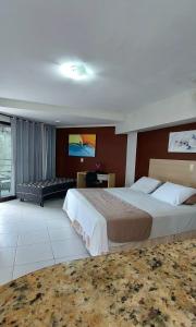 um quarto de hotel com uma cama grande e uma televisão em Marsallis Residence Flat-EFM601 em Natal
