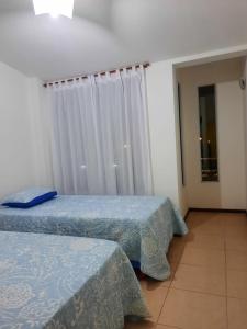 a bedroom with two beds and a window with curtains at Loma Blanca in Libertador General San Martín