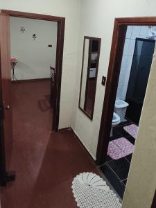 przedpokój z lustrem i toaletą w pokoju w obiekcie Apt térreo com 3 qtos e 1 vaga w mieście Poços de Caldas