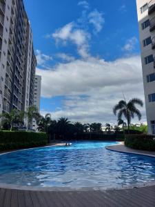 a swimming pool in the middle of two buildings at 1BR Condo Unit by Nartleb Staycation in Manila