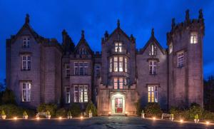 um velho castelo à noite com luzes acesas em Kinnitty Castle Hotel em Kinnitty