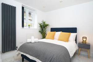 a bedroom with a large bed with yellow pillows at Boutique Flat near O2 & Excel in London