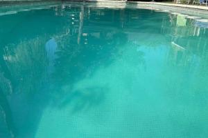 a pool of blue water with a reflection in it at Casa con piscina privada climatizada e iluminada en exclusivo Golf Country Club Campo de Golf de 18 hoyos Piscina cubierta climatiza del club Canchas de futbol y tenis profesionales iluminadas Recreación Infantil Market y todo tipo de servicios in Buenos Aires +118 photos