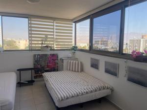 een kamer met een bank in een kamer met ramen bij 123Eilat tzofit in Eilat