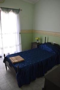 Un dormitorio con una cama azul y una ventana en Casa Lucía en Villa Unión