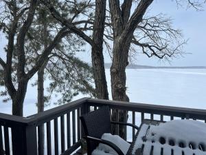 a table and a chair on a deck with snow at The Point - On Gull Lake in Brainerd