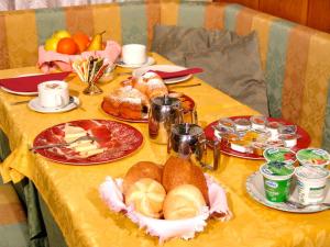 una mesa con platos de comida en un mantel amarillo en Jolly B&B - Affittacamere, en Dimaro