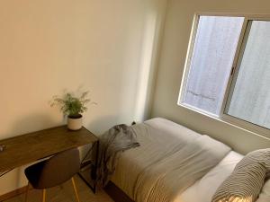 1 dormitorio con cama, escritorio y ventana en Private Room at The Zen Den en Ciudad de México
