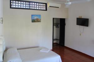 a bedroom with a bed and a television in a room at Hotel Albatros in Puerto Escondido