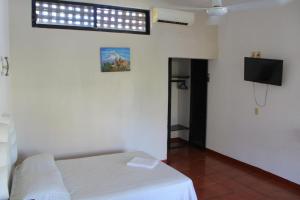 1 dormitorio con 1 cama y TV en una habitación en Hotel Albatros, en Puerto Escondido