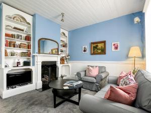 a living room with a couch and a fireplace at Alice's Cottages in Launceston