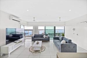 a living room with two couches and a table at Spectacular Darwin apartment in Darwin
