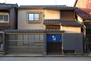 una casa con una lona azul sobre el garaje en 宿樽, en Kanazawa