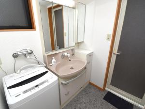 Baño pequeño con lavabo y espejo en 宿樽, en Kanazawa